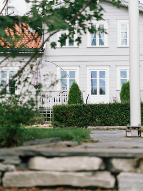 Hvite sprossevinduer lyser opp mot lys grå kledning