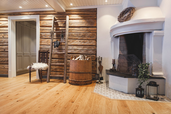 Lyst listverk i kontrast til brun tømmervegg i stua