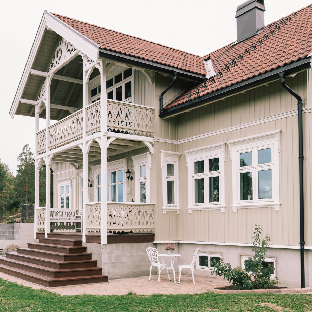 Sveitserveranda med rekkverk, snekkerglede og synlig konstruksjon