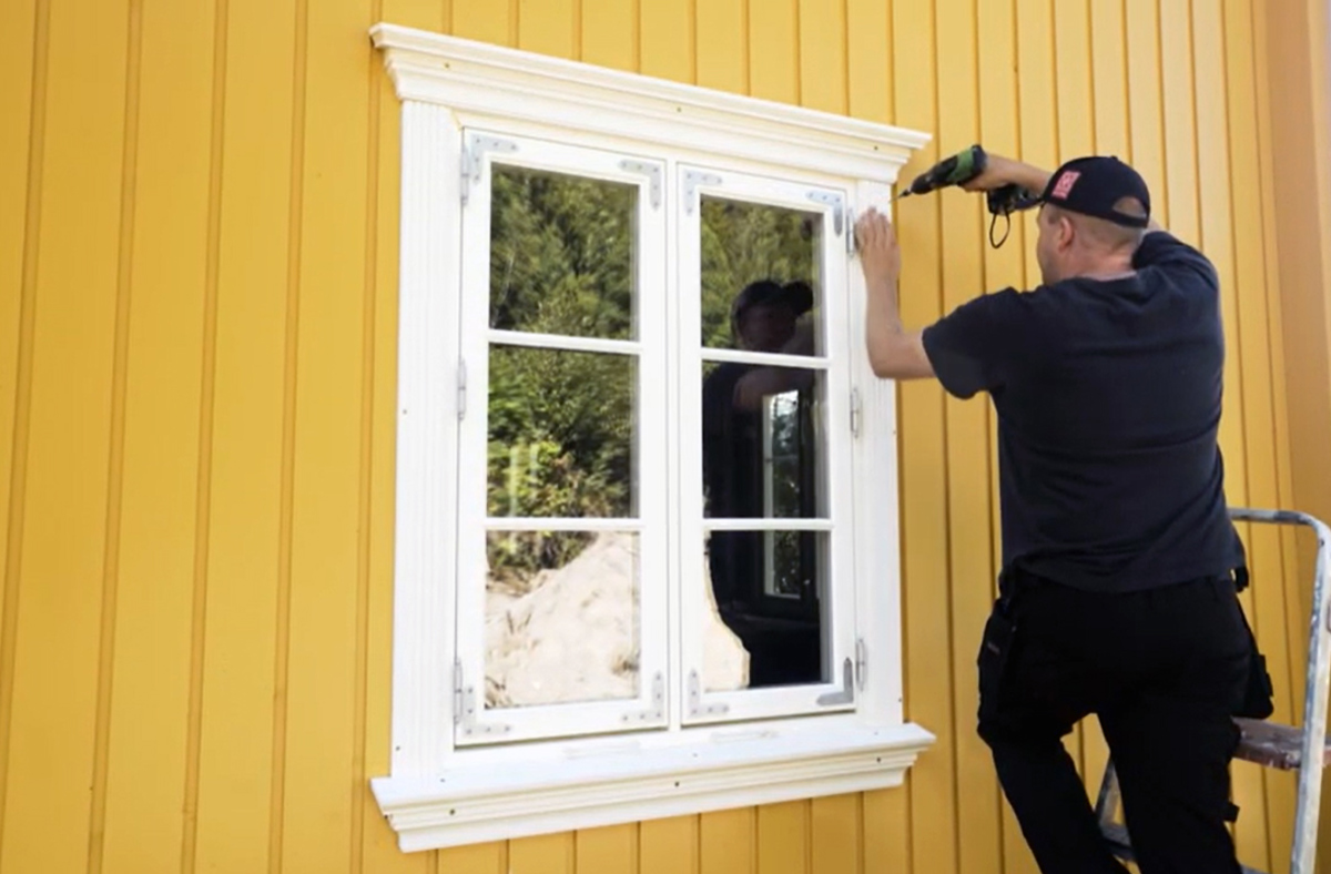 Mann som monterer klassisk vindusomramming