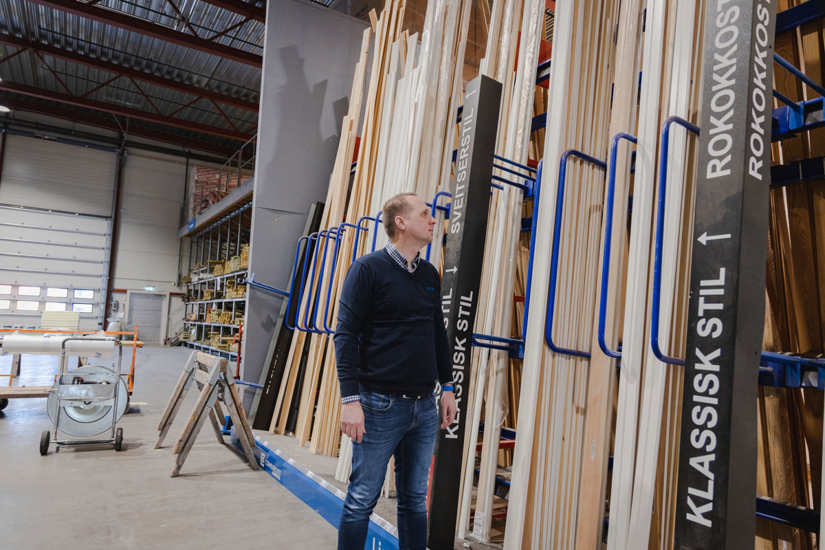 Mann titter på reol med lister fra Stiltre